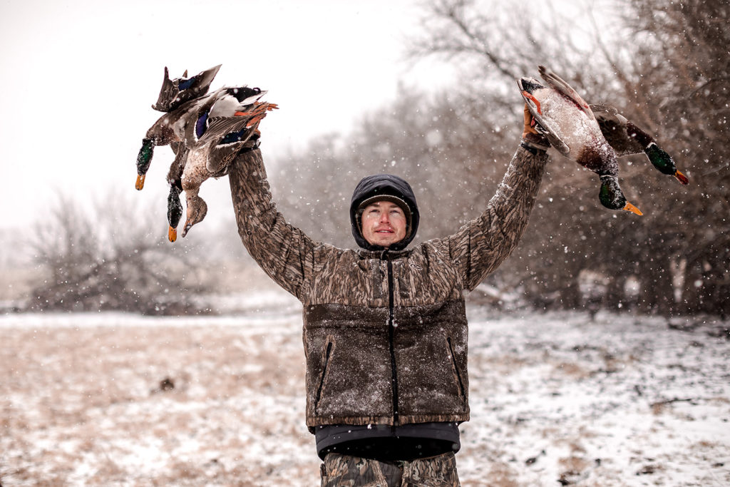 Hunter holding up ducks